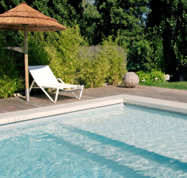 a serviced pool with loungers and gardens