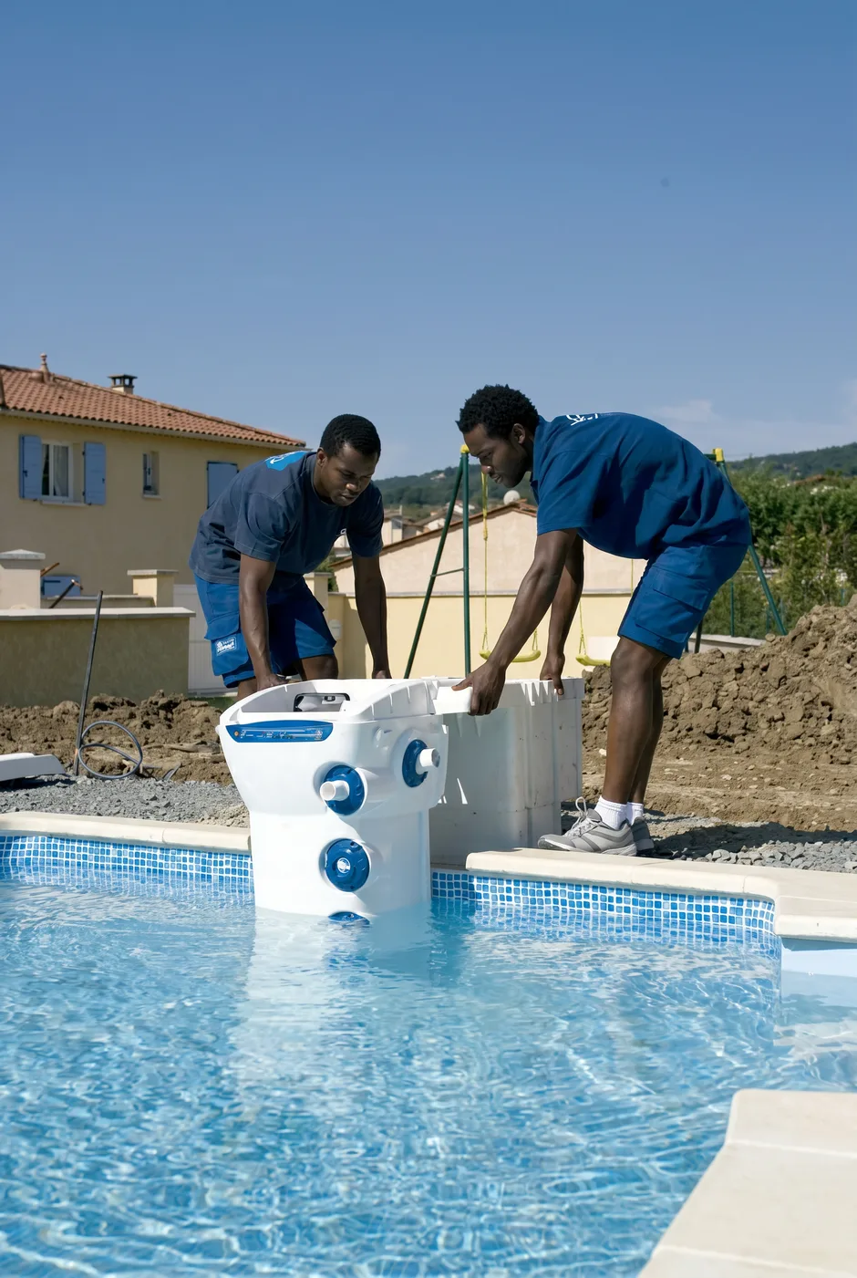 two technicians installing a pool filtration unit